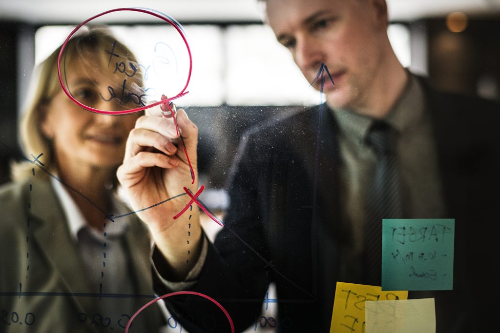 Businesspeople planning on a glass wall
